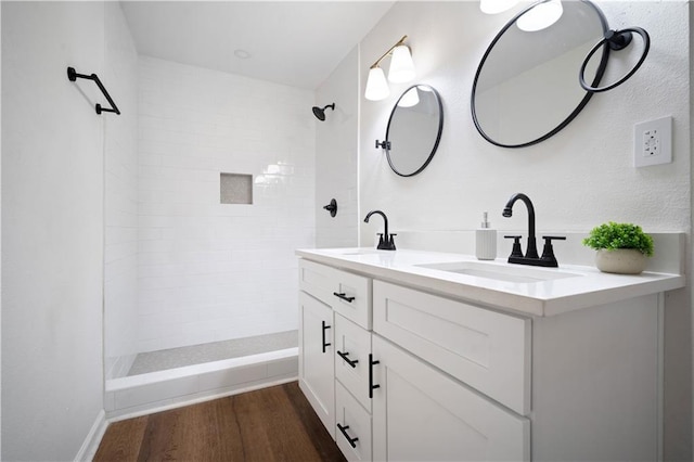 3001 Demetropolis Rd, Mobile, AL 36693 - bathroom with a sink, double vanity, a tile shower, and wood finished floors
