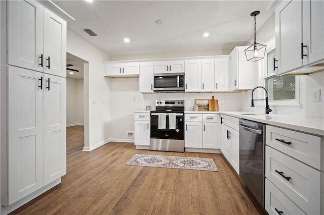 3001 Demetropolis Rd, Mobile, AL 36693 - kitchen with visible vents, appliances with stainless steel finishes, wood finished floors, and tasteful backsplash