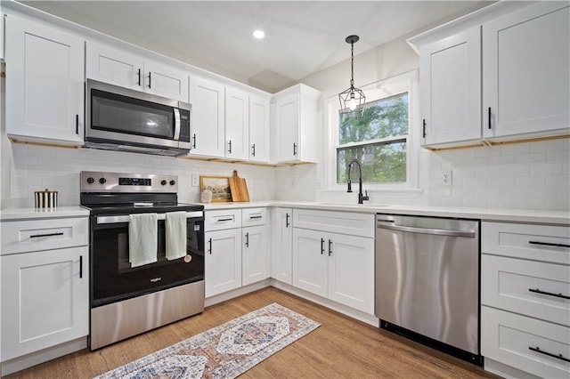 3001 Demetropolis Rd, Mobile, AL 36693 - kitchen featuring a sink, light countertops, light wood-style flooring, stainless steel appliances, and white cabinetry