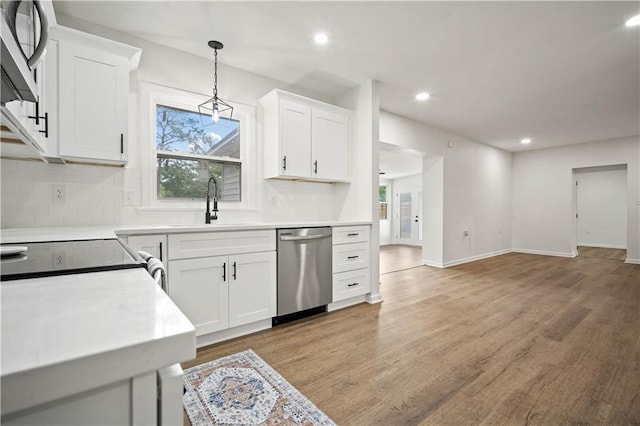3001 Demetropolis Rd, Mobile, AL 36693 - kitchen featuring decorative backsplash, appliances with stainless steel finishes, a sink, light wood-style floors, and white cabinetry