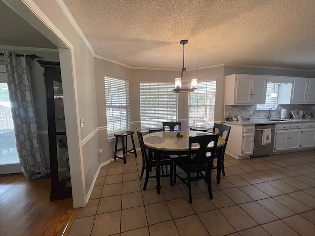 dining space featuring light tile patterned floors, baseboards, an inviting chandelier, and crown molding