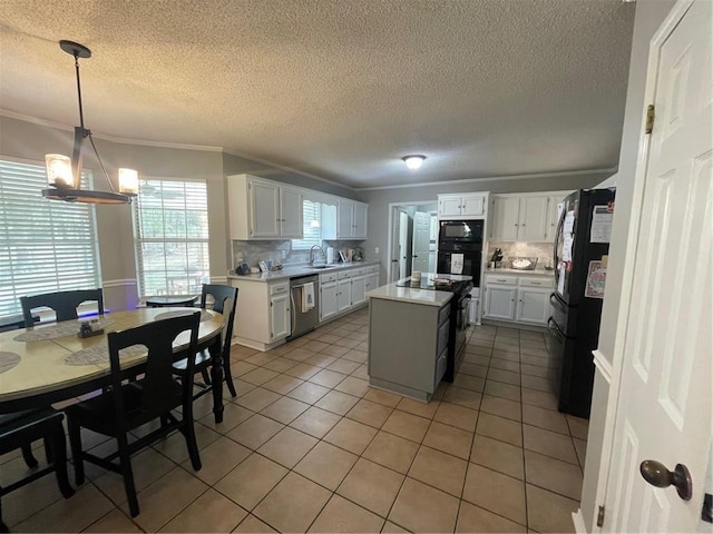 kitchen with backsplash, a kitchen island, ornamental molding, light tile patterned floors, and black appliances