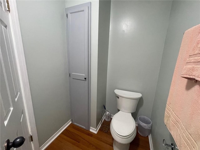 bathroom featuring toilet, baseboards, and wood finished floors