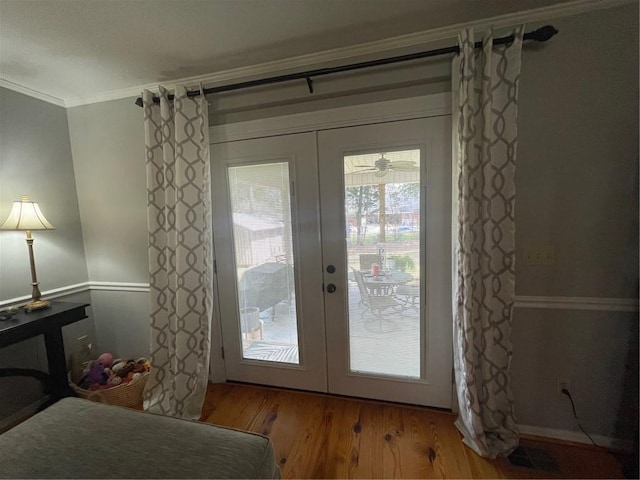 doorway featuring crown molding, wood finished floors, and french doors