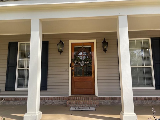 view of exterior entry featuring covered porch