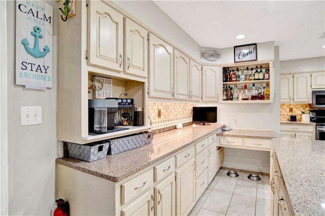 8717 Louis Poiroux Rd N, Theodore, AL 36582 - kitchen featuring stainless steel appliances, backsplash, light tile patterned floors, open shelves, and light stone counters