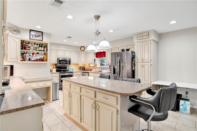 8717 Louis Poiroux Rd N, Theodore, AL 36582 - kitchen with stainless steel appliances, light tile patterned floors, a kitchen bar, a kitchen island, and recessed lighting