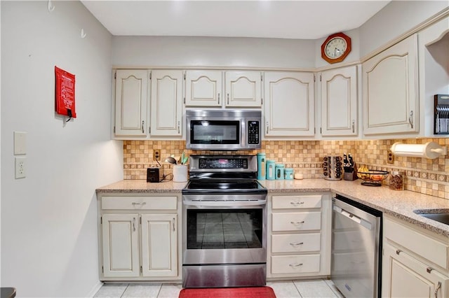 8717 Louis Poiroux Rd N, Theodore, AL 36582 - kitchen featuring stainless steel appliances, backsplash, light tile patterned floors, and light stone countertops