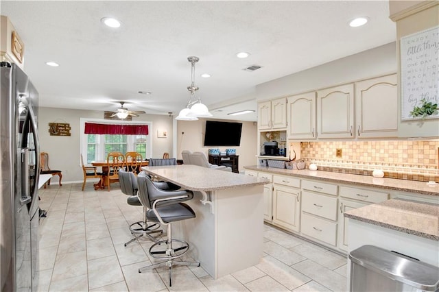 8717 Louis Poiroux Rd N, Theodore, AL 36582 - kitchen featuring stainless steel refrigerator with ice dispenser, backsplash, a breakfast bar, pendant lighting, and recessed lighting