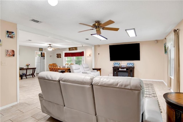 8717 Louis Poiroux Rd N, Theodore, AL 36582 - living room with ceiling fan, baseboards, and a textured ceiling