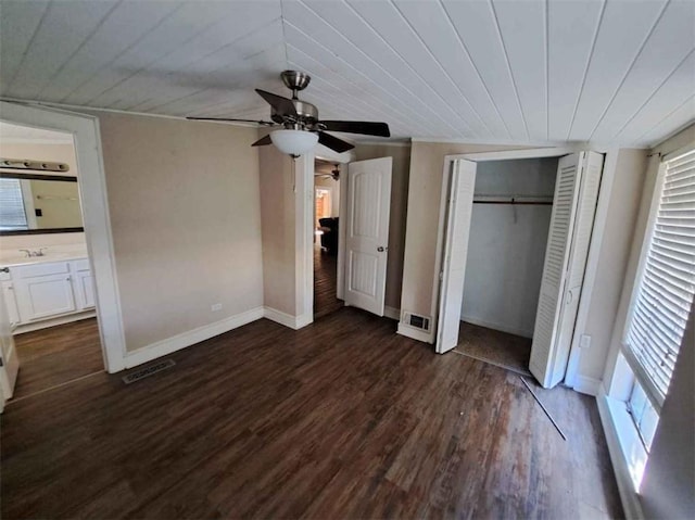 unfurnished bedroom featuring ceiling fan, wooden ceiling, ensuite bathroom, and dark hardwood / wood-style flooring