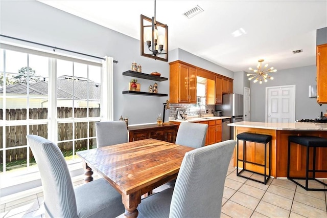 dining area featuring visible vents, a notable chandelier, and light tile patterned flooring