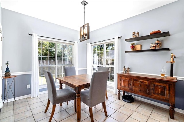 dining area featuring an inviting chandelier, light tile patterned floors, and baseboards