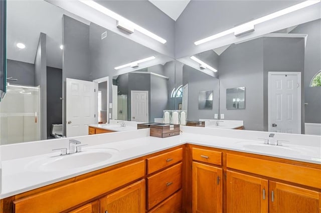 full bath featuring double vanity, an enclosed shower, and a sink