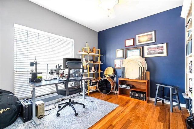 office space featuring a ceiling fan, baseboards, and wood finished floors