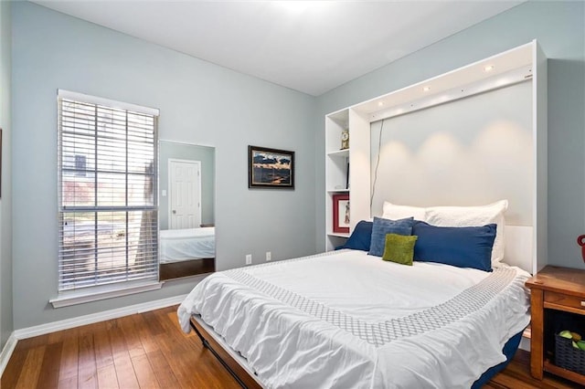 bedroom with hardwood / wood-style flooring and baseboards