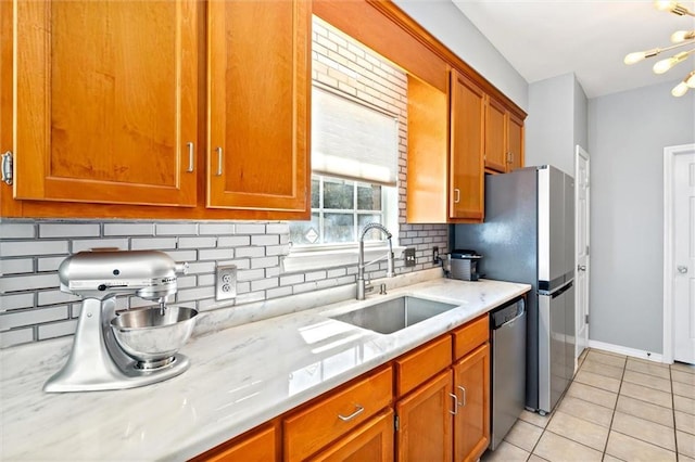 kitchen with light tile patterned floors, a sink, light countertops, stainless steel dishwasher, and tasteful backsplash