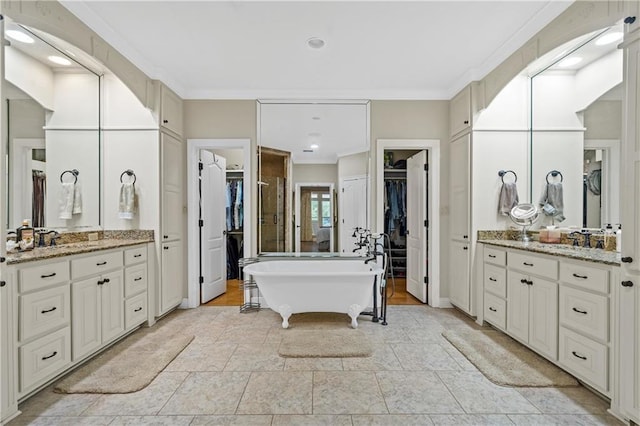 10188 Rosewood Ln, Daphne, AL 36526 - bathroom with ornamental molding, a walk in closet, two vanities, a freestanding tub, and recessed lighting