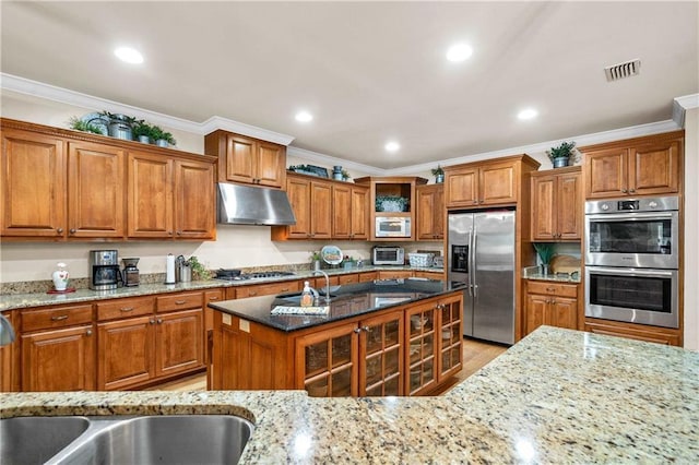 10188 Rosewood Ln, Daphne, AL 36526 - kitchen featuring appliances with stainless steel finishes, under cabinet range hood, brown cabinets, light stone counters, and crown molding
