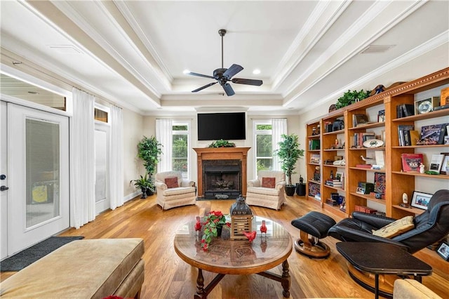 10188 Rosewood Ln, Daphne, AL 36526 - sitting room featuring a raised ceiling, crown molding, ceiling fan, light wood-style floors, and a fireplace