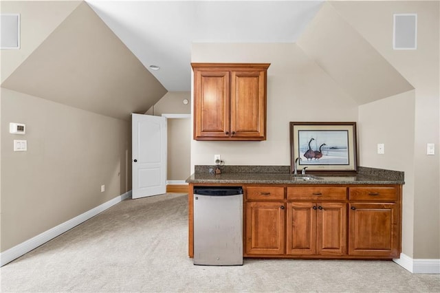 10188 Rosewood Ln, Daphne, AL 36526 - kitchen with brown cabinets, lofted ceiling, light colored carpet, baseboards, and a sink