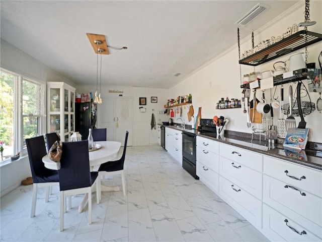 kitchen with black appliances, pendant lighting, white cabinetry, and plenty of natural light