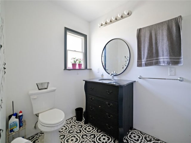 bathroom featuring toilet, vanity, and tile patterned flooring