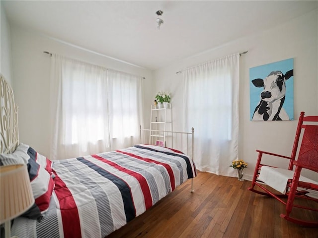 bedroom featuring multiple windows and dark hardwood / wood-style floors