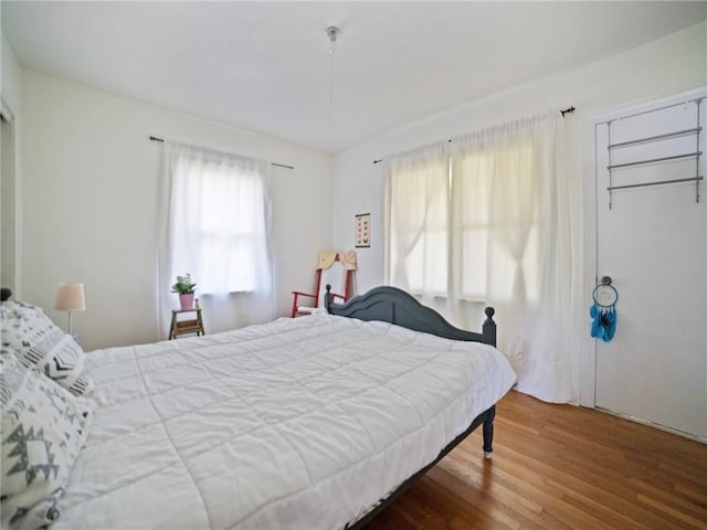 bedroom with wood-type flooring and multiple windows