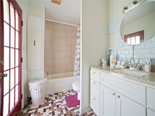 full bathroom with toilet, vanity, shower / bath combination with curtain, and decorative backsplash