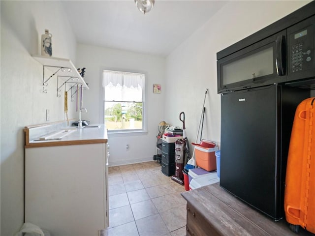 laundry room featuring light tile patterned floors and sink