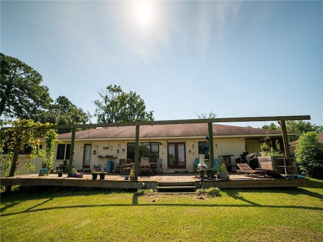 rear view of property with french doors, a yard, and a wooden deck