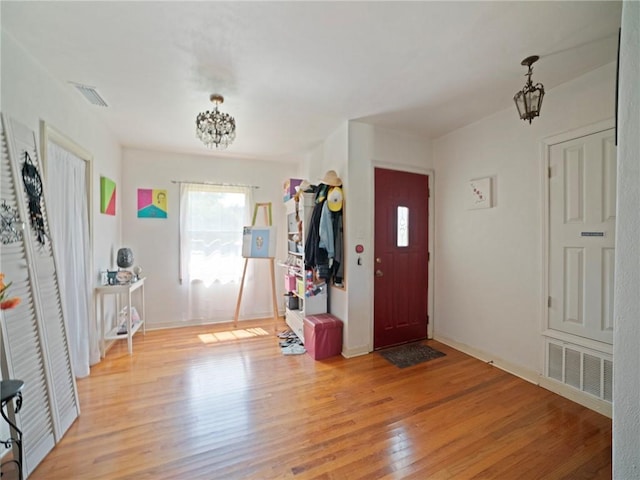 foyer with light wood-type flooring and a chandelier