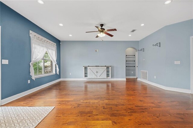 unfurnished living room featuring ceiling fan and hardwood / wood-style flooring