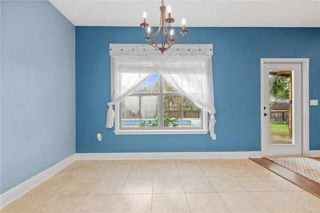 unfurnished dining area with an inviting chandelier and light tile patterned flooring