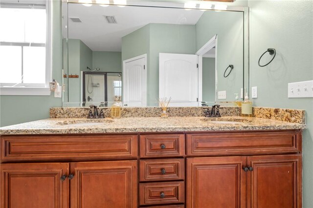 bathroom featuring vanity and a shower with shower door