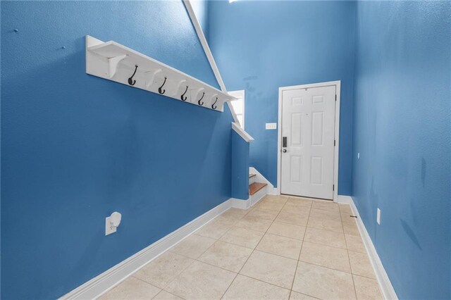 entrance foyer with a towering ceiling and light tile patterned floors