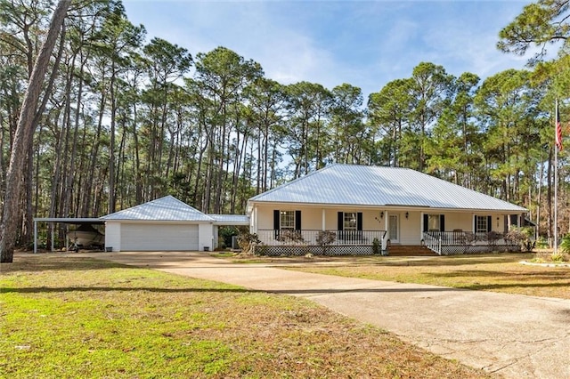 ranch-style house featuring a carport, a garage, covered porch, an outbuilding, and a front lawn