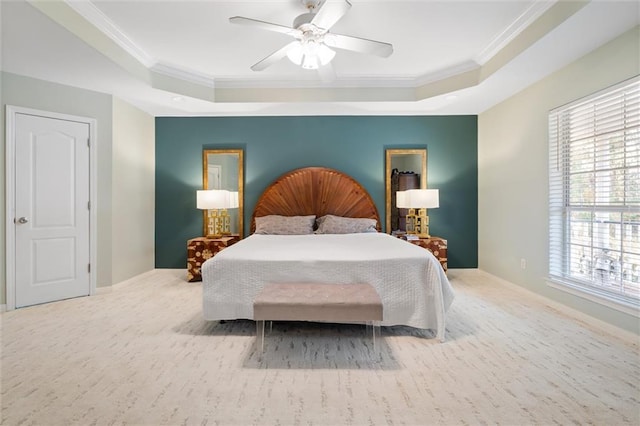 bedroom featuring light carpet, a tray ceiling, ornamental molding, and ceiling fan