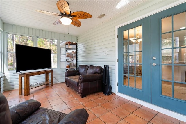 sunroom / solarium with ceiling fan and french doors