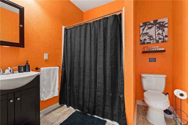 bathroom with walk in shower, toilet, hardwood / wood-style flooring, and vanity