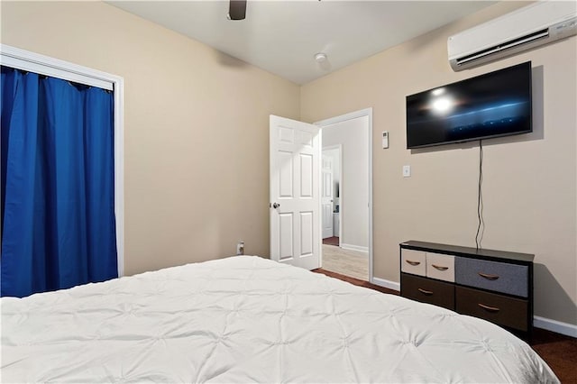 bedroom with hardwood / wood-style flooring, ceiling fan, and a wall mounted air conditioner