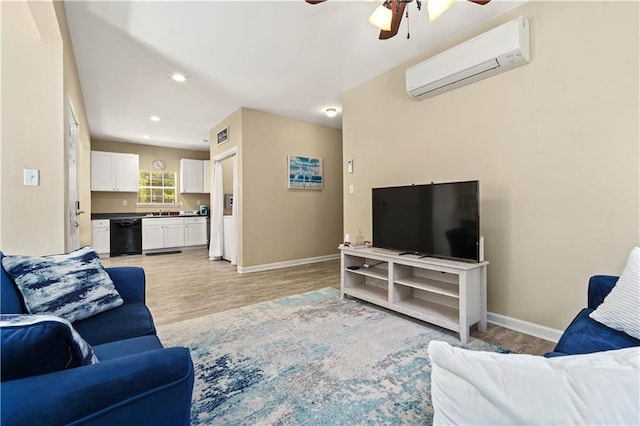 living room with a wall unit AC, sink, ceiling fan, and light hardwood / wood-style floors