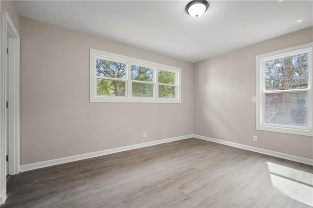 unfurnished room with wood finished floors and baseboards