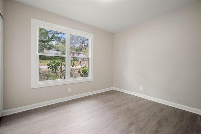 empty room featuring wood finished floors and baseboards