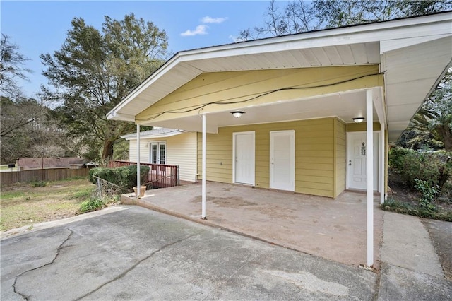 exterior space featuring a carport and fence