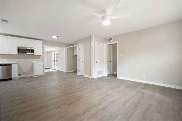 unfurnished living room featuring light wood-style flooring, visible vents, and baseboards