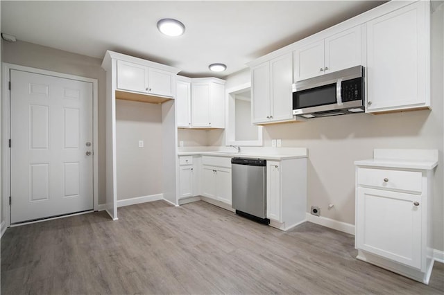 kitchen featuring white cabinets, light wood-style floors, and stainless steel appliances