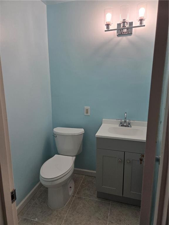 bathroom featuring tile patterned flooring, vanity, and toilet