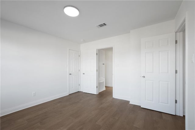 unfurnished bedroom with dark hardwood / wood-style floors and a closet